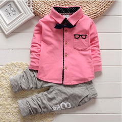 Stylish children's clothing displayed on hangers in a boutique, showcasing vibrant colors and trendy designs.