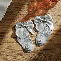 Knee high classy formal dress featuring a big bow, perfect for elegant occasions and sophisticated events.